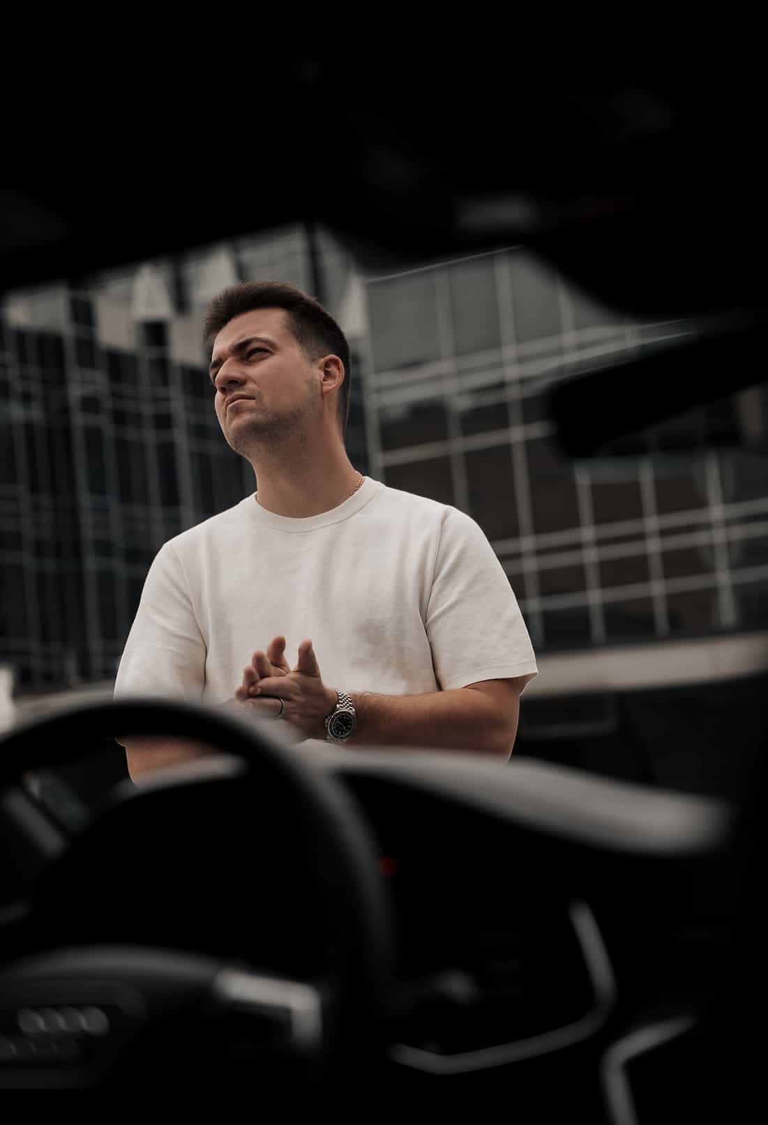 Creative portrait of photographer Ivan Cheb in front of a modern glass building in Pittsburgh
