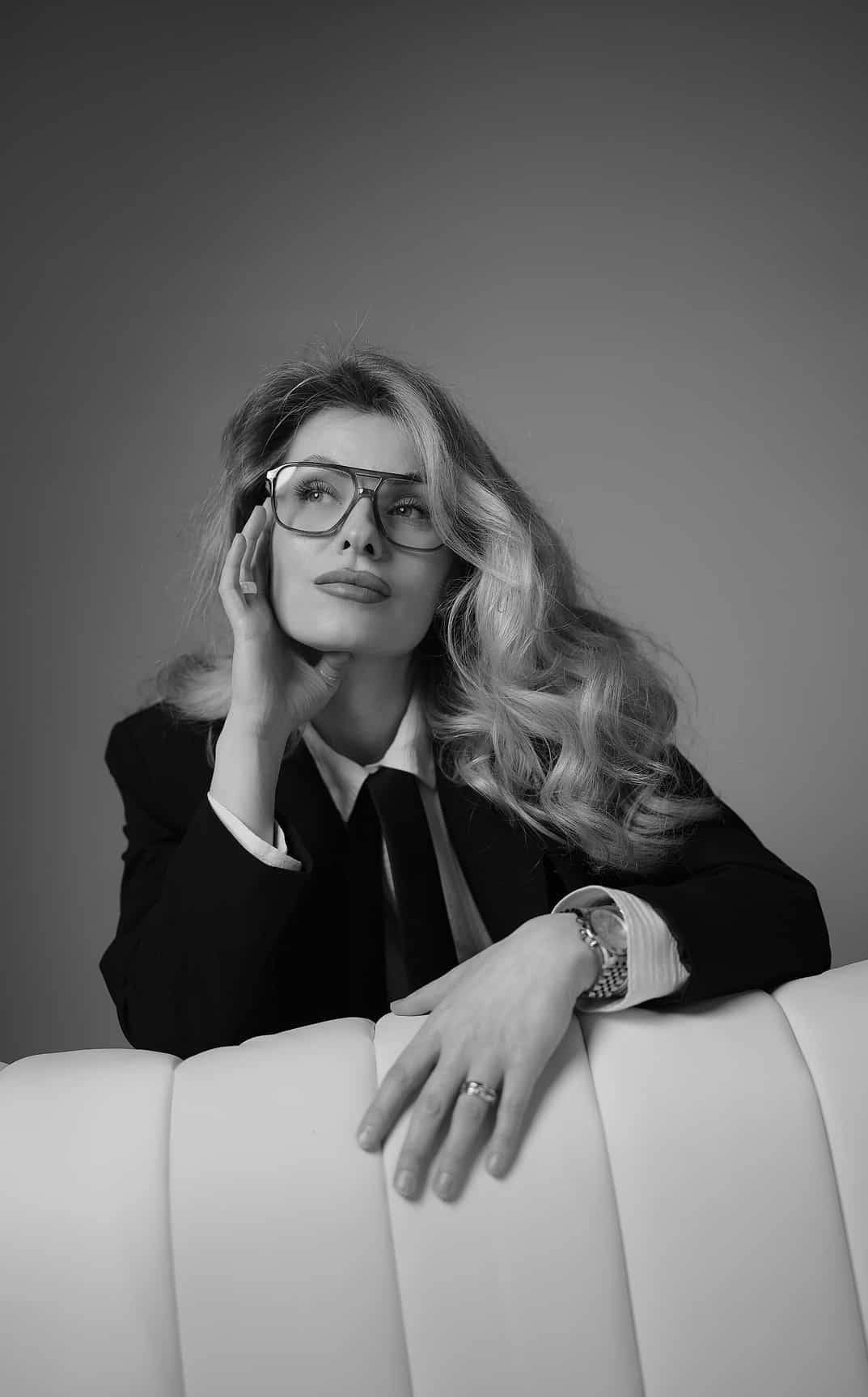 Professional studio portrait of a woman sitting on a white couch