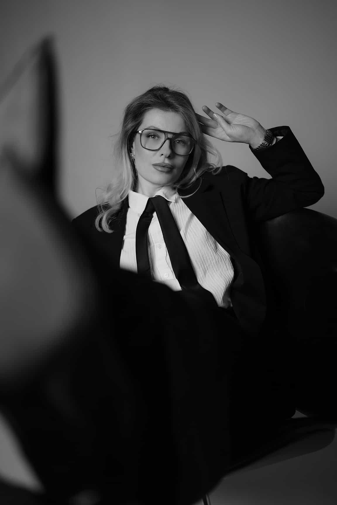 Creative black and white fashion portrait of a woman in glasses